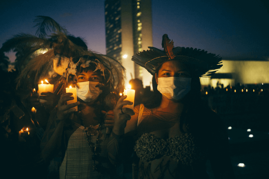 Mulheres indígenas em Brasília segurando velas